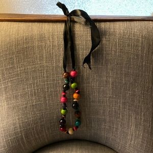 This beautiful wood necklace with black stripes string multiple colors .